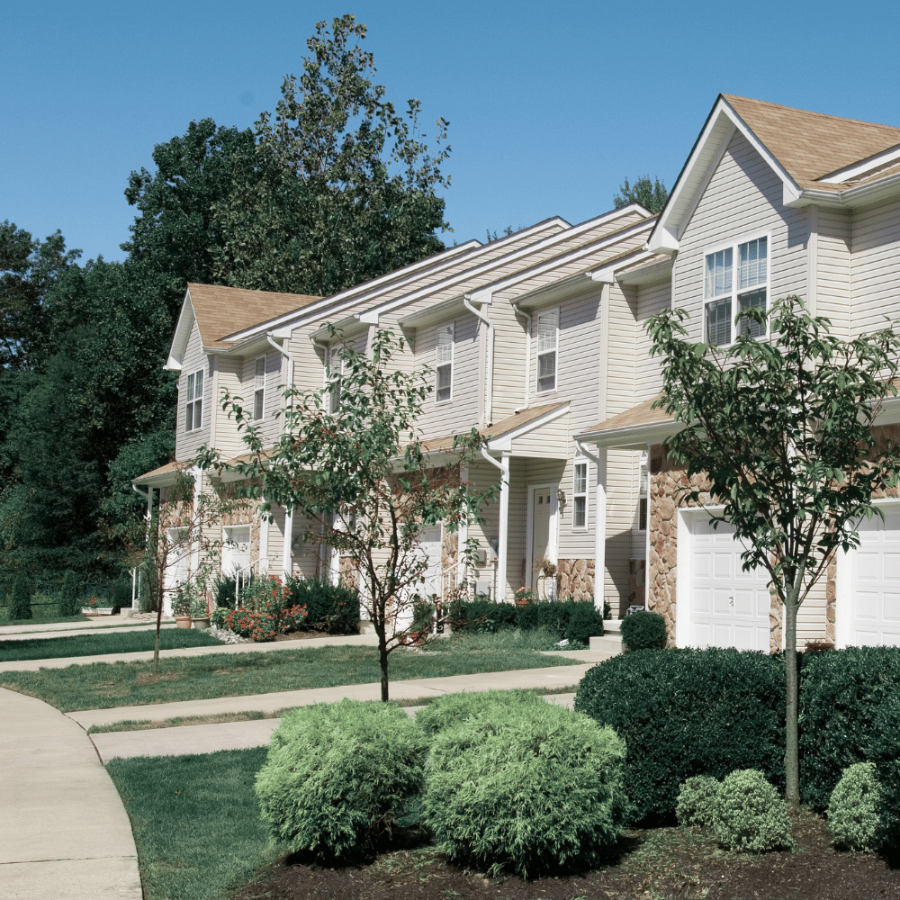 A row of townhomes in a landscaped outdoor environment with sidewalks