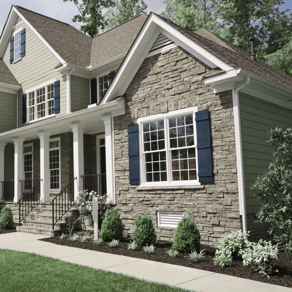 A home with a sidewalk and landscaped beds with plants